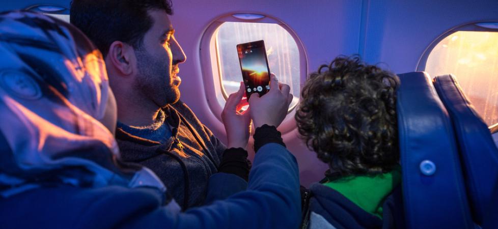 family looking on the plane window